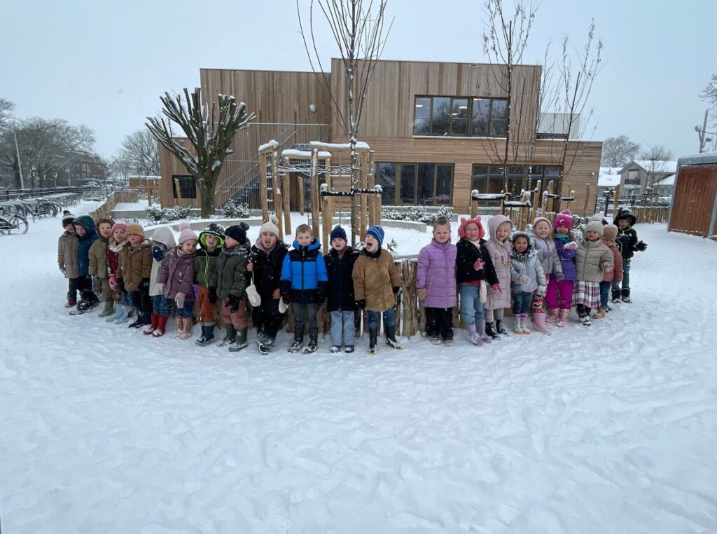 Kinderen spelen buiten in de sneeuw op het schoolplein van Kindcentrum Hof van Oranje